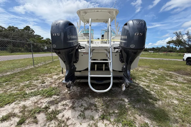 Slide: The Image of 2022 World Cat 230 DC boat with dual Yamaha 115 engines, parked on grass. - 28