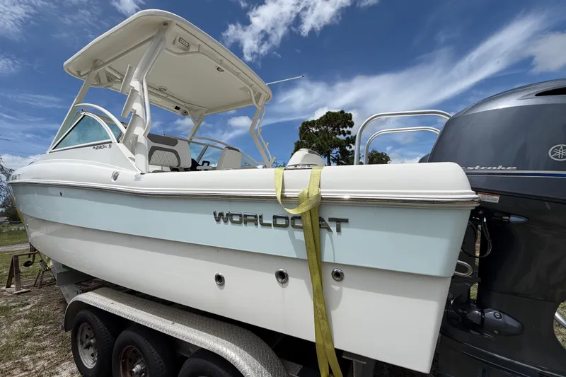 Slide: The Image of 2022 World Cat 230 DC boat on trailer under blue sky. - 14