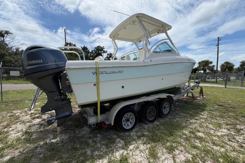 Slide: The Image of 2022 World Cat 230 DC boat on trailer with Yamaha outboard motor, parked outdoors. - 32