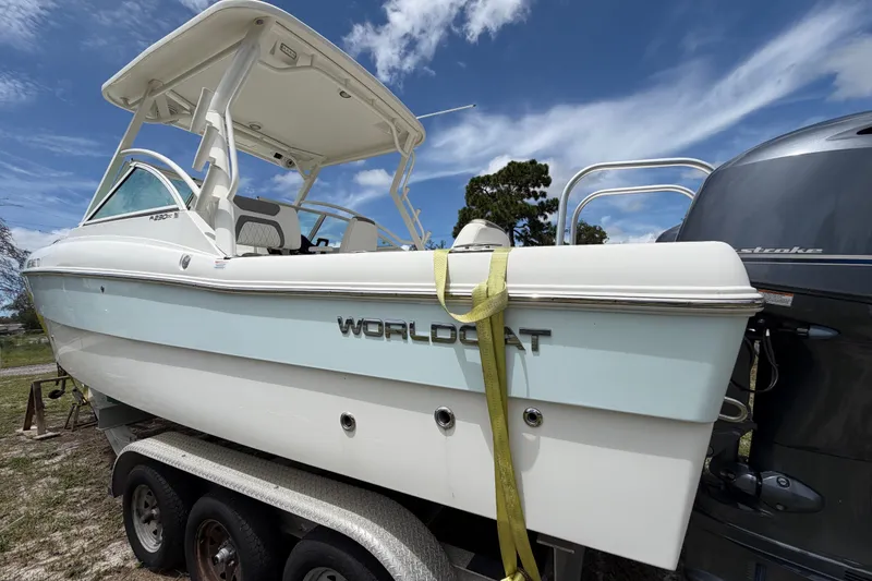 Slide: The Image of 2022 World Cat 230 DC boat on trailer under clear blue sky. - 13