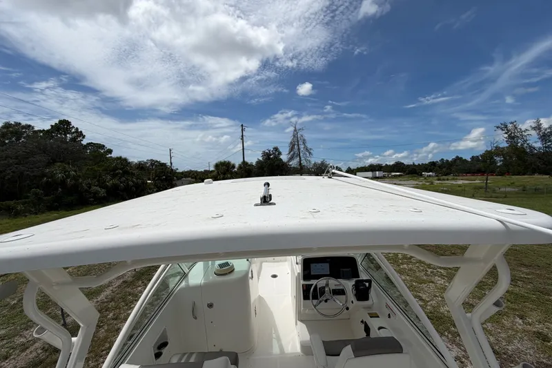Slide: The Image of 2022 World Cat 230 DC boat with helm and seating, under a clear blue sky. - 52