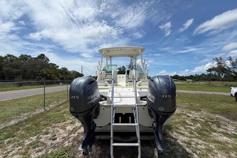 Slide: The Image of 2022 World Cat 230 DC boat with twin Yamaha 115 engines under a clear blue sky. - 30