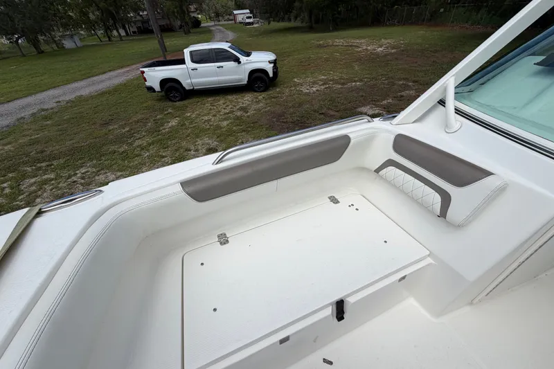 Slide: The Image of 2022 World Cat 230 DC boat interior with white pickup truck in background. - 70