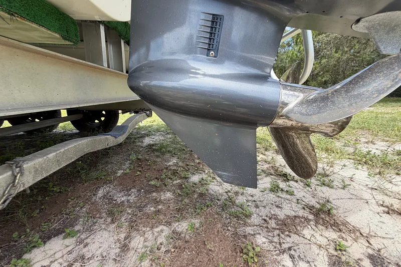 Slide: The Image of Close-up of a 2022 World Cat 230 DC boat propeller and trailer on grass. - 23