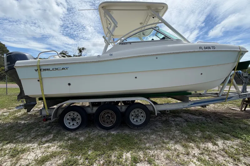 Slide: The Image of 2022 World Cat 230 DC boat on trailer under a partly cloudy sky. - 33