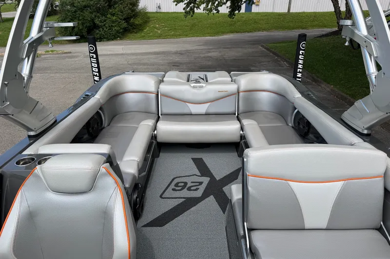 Slide: The Image of 2018 MasterCraft X26 boat interior with silver seating and orange accents. - 10