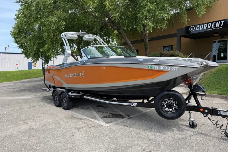Slide: The Image of 2018 MasterCraft X26 boat on trailer, parked outside Current Watersports. - 2
