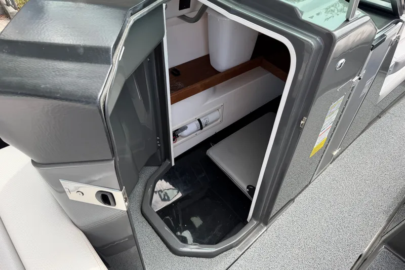 Slide: The Image of 2018 MasterCraft X26 boat interior showing storage compartment and seating area. - 13