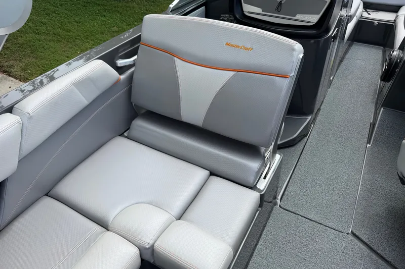 Slide: The Image of 2018 MasterCraft X26 boat interior with gray seating and orange accents. - 14