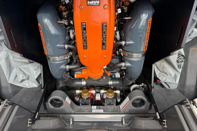 Slide: The Image of 2018 MasterCraft X26 engine compartment featuring an Ilmor engine with orange and gray components. - 17