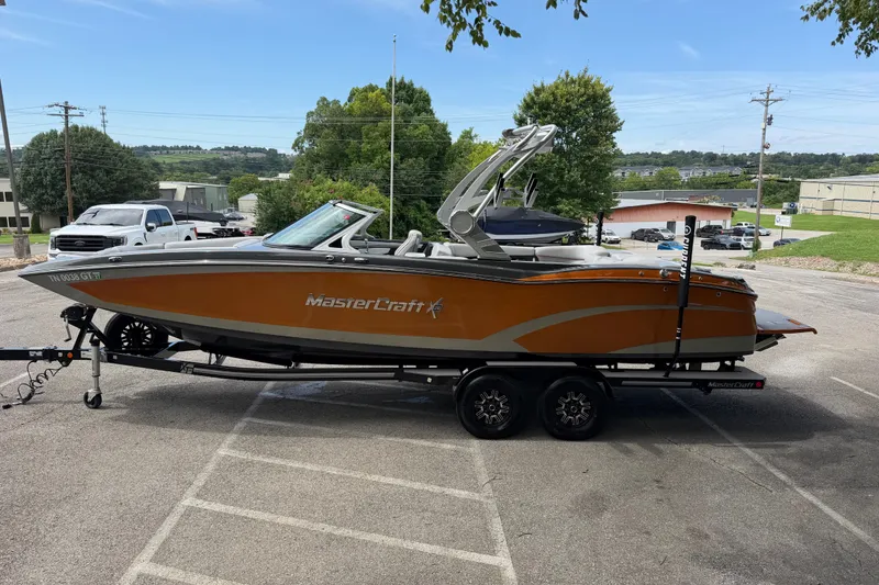 Slide: The Image of 2018 MasterCraft X26 boat on trailer in parking lot, side view. - 5