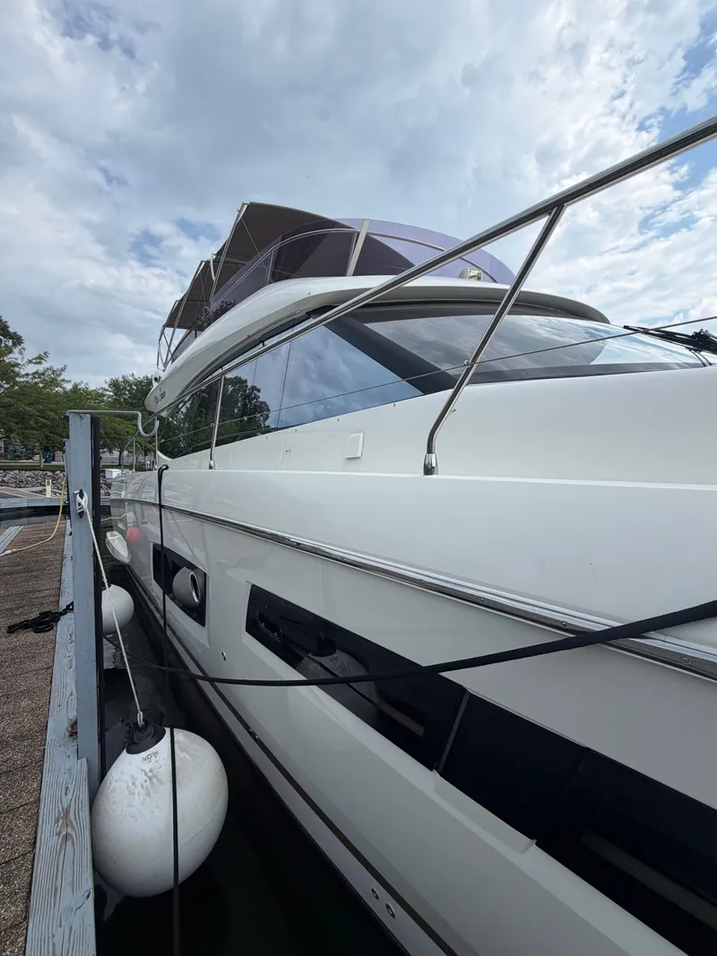 Slide: The Image of A 2015 Prestige 550 yacht docked. It features a sleek, modern design with a white exterior. - 5