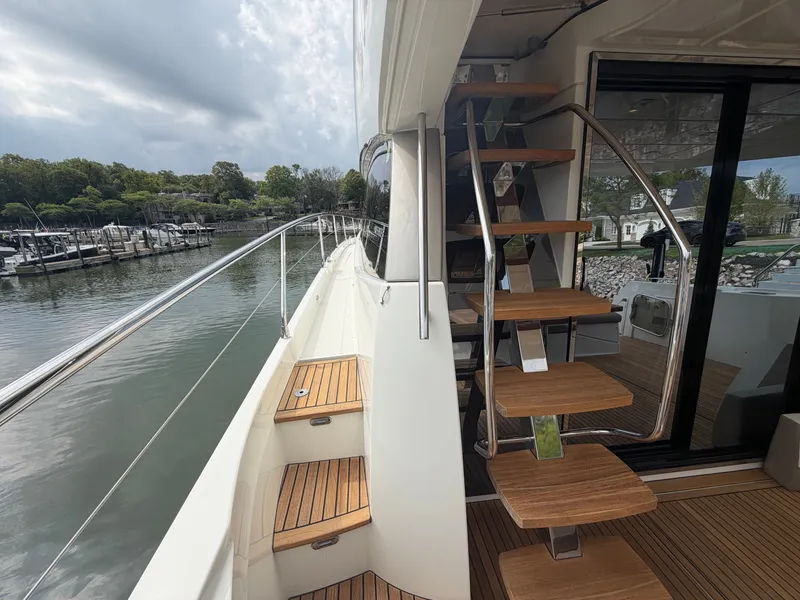 Slide: The Image of The 2015 Prestige 550 features an elegant staircase and side walkway with wood accents. - 10