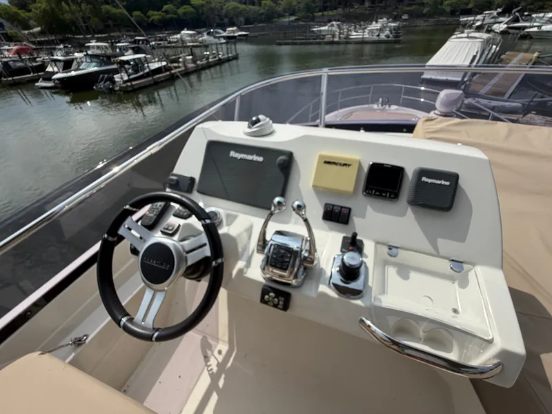 Slide: The Image of The image shows the helm of a 2015 Prestige 550 with various instruments and a steering wheel. - 48