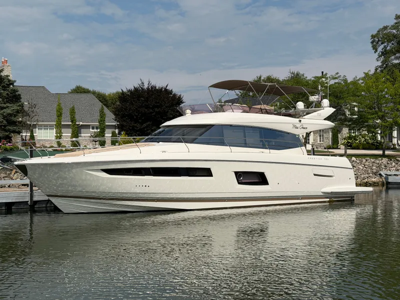 Slide: The Image of A luxurious 2015 Prestige 550 yacht docked in calm waters, surrounded by trees. - 1