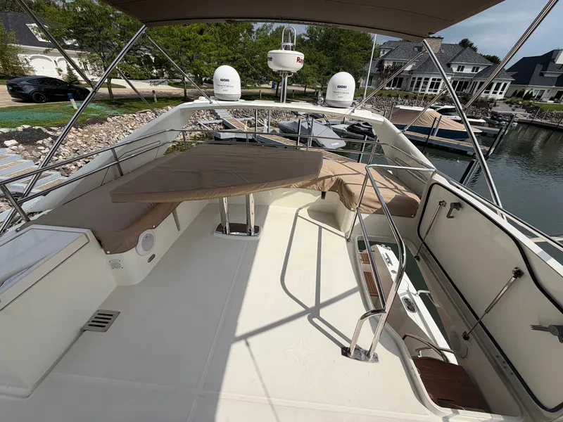 Slide: The Image of The image shows the deck of a 2015 Prestige 550 with seating area and table. - 46