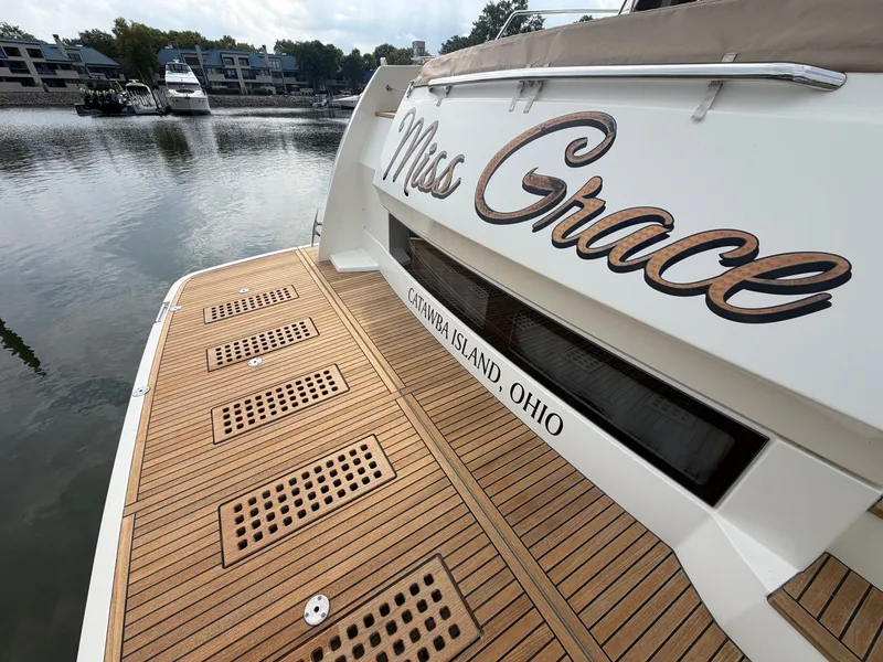 Slide: The Image of The yacht "Miss Grace" is docked, featuring a sleek wooden deck and a calm waterfront setting. - 3