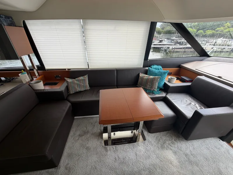 Slide: The Image of Interior of a 2015 Prestige 550 with elegant leather seating and a wooden table. - 17