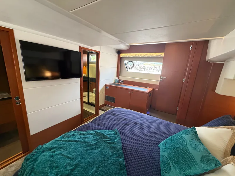 Slide: The Image of The cabin of a 2015 Prestige 550 with a bed, TV, and window. - 41
