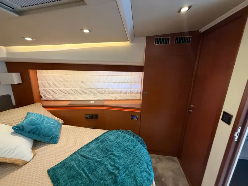 Slide: The Image of Luxurious cabin with double bed, wood paneling, and window with curtain. - 28