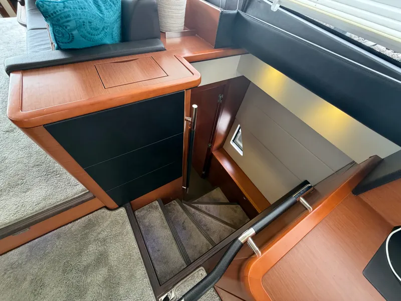 Slide: The Image of An elegant staircase leads to the lower deck of the yacht, surrounded by wood paneling and modern details. - 35
