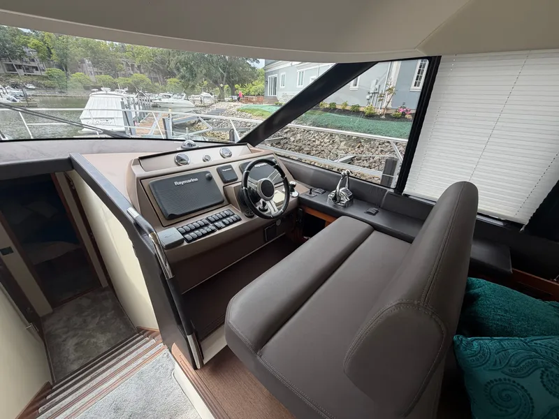 Slide: The Image of The cockpit of a 2015 Prestige 550 with a modern helm and comfortable seating. - 20