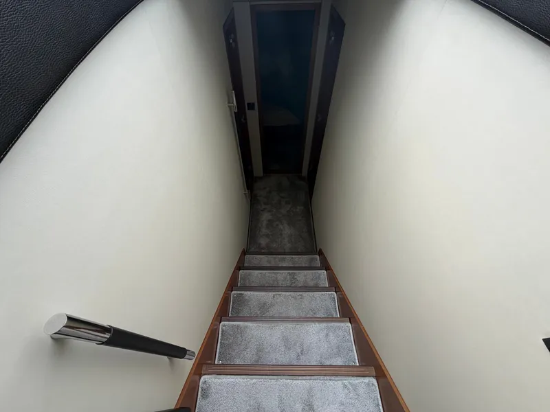 Slide: The Image of A narrow carpeted staircase leads down to the lower area of the yacht. - 24