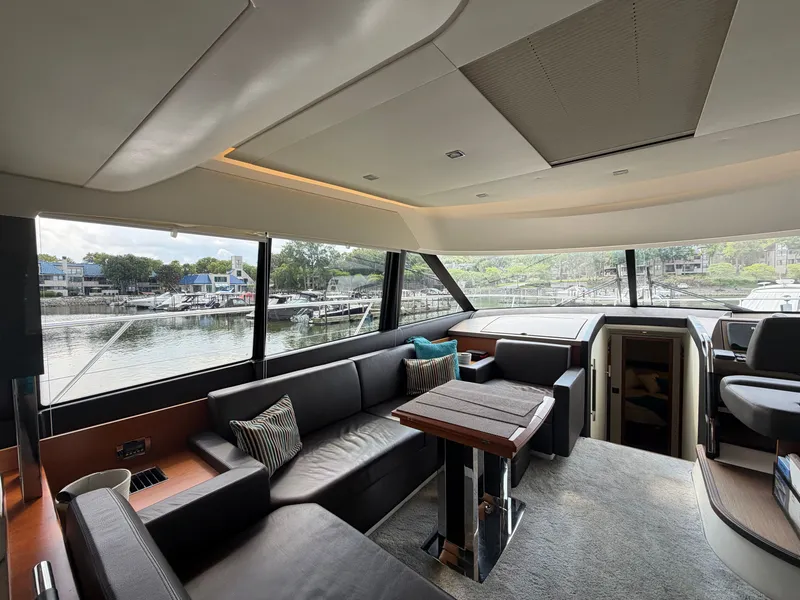 Slide: The Image of Interior of a 2015 Prestige 550 yacht with elegant seating area and panoramic windows. - 19