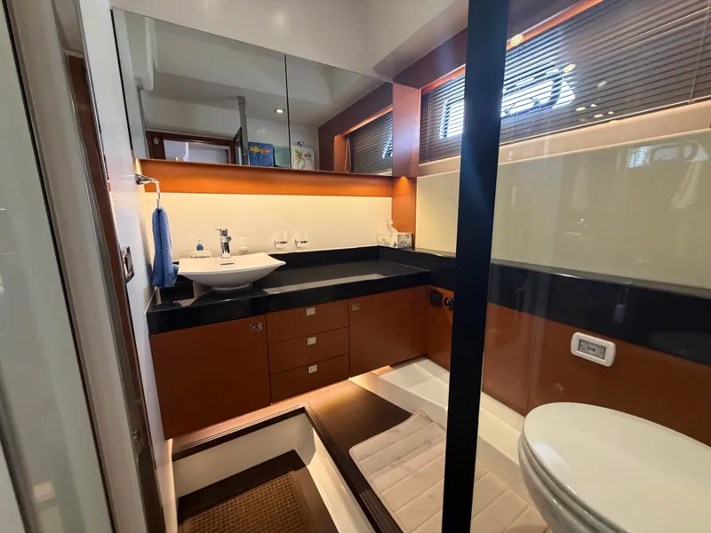 Slide: The Image of The image shows a modern yacht bathroom with a sink, toilet, and wood paneling. - 43
