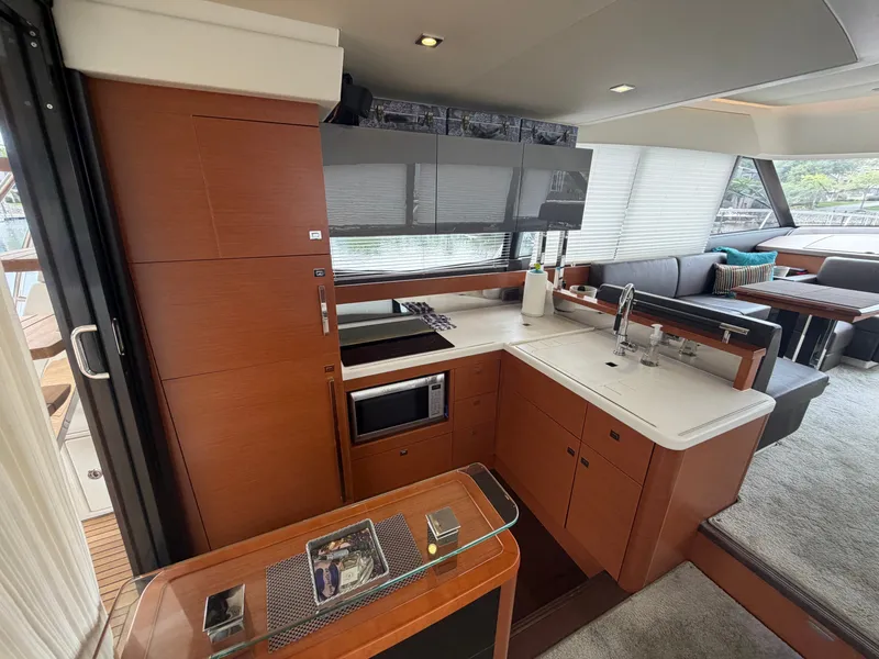 Slide: The Image of The galley of a 2015 Prestige 550 yacht with modern appliances and sleek wood paneling. - 13