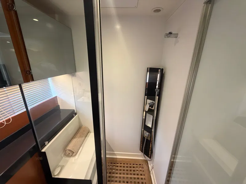 Slide: The Image of The yacht's shower features a modern glass enclosure and wooden flooring. - 34