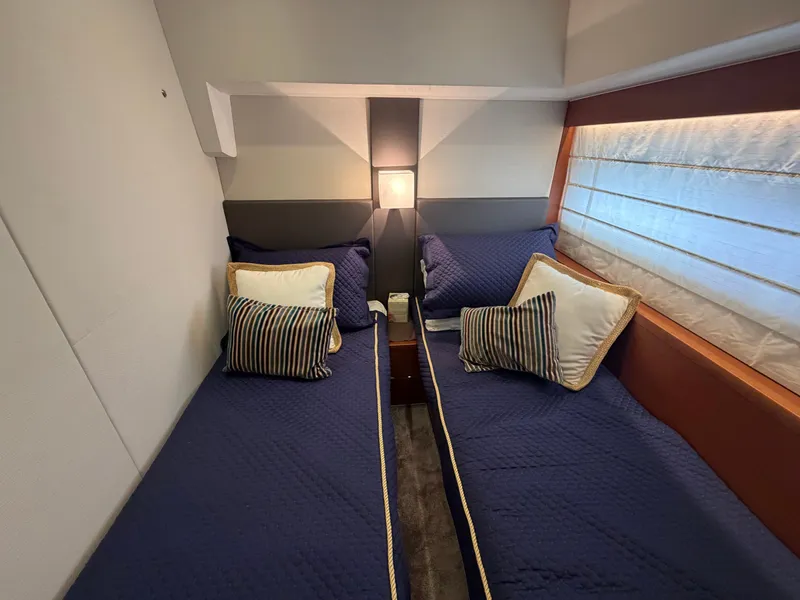 Slide: The Image of Two single beds in an elegant cabin with blue covers and striped pillows. - 30