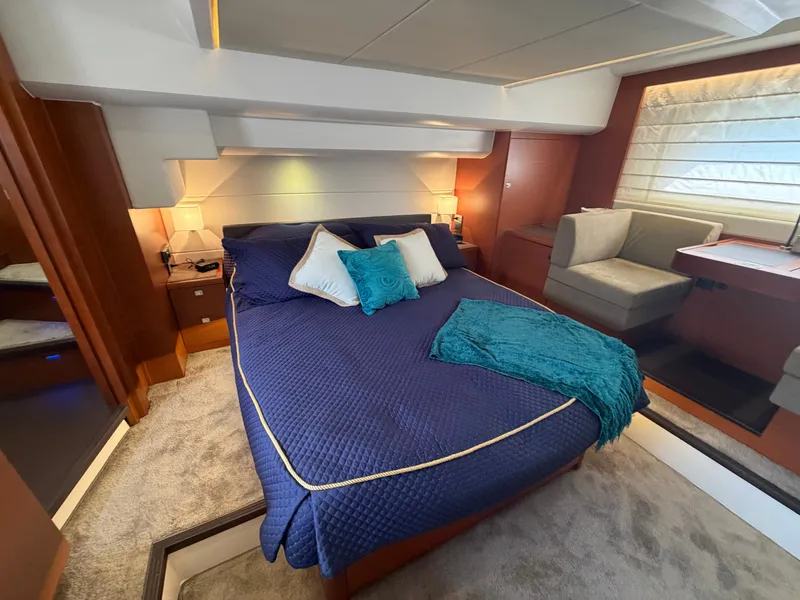 Slide: The Image of Luxurious cabin with a large bed, blue bedding, and elegant lighting on a Prestige 550 yacht. - 39