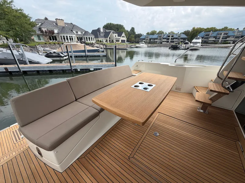 Slide: The Image of A luxury yacht with a sleek wooden table and cushioned seating at the dock. - 7