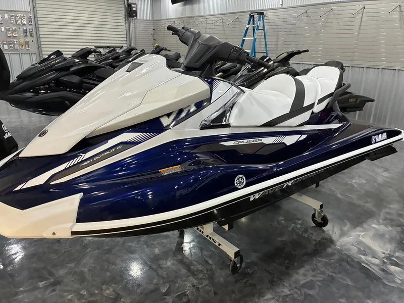The Image of A 2018 Yamaha VX Cruiser is displayed in a showroom. It features a sleek blue and white design. - 1