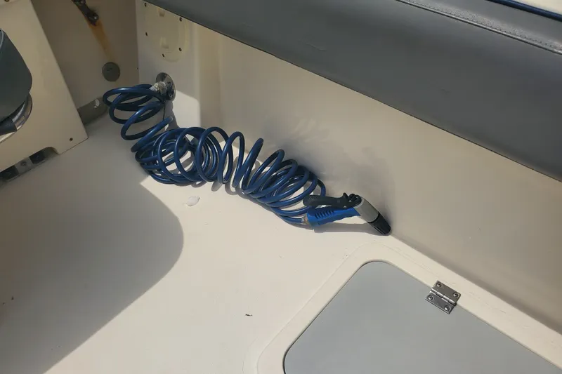 Slide: The Image of Coiled blue hose in 2022 Defiance Commander 220 EX boat interior. - 18