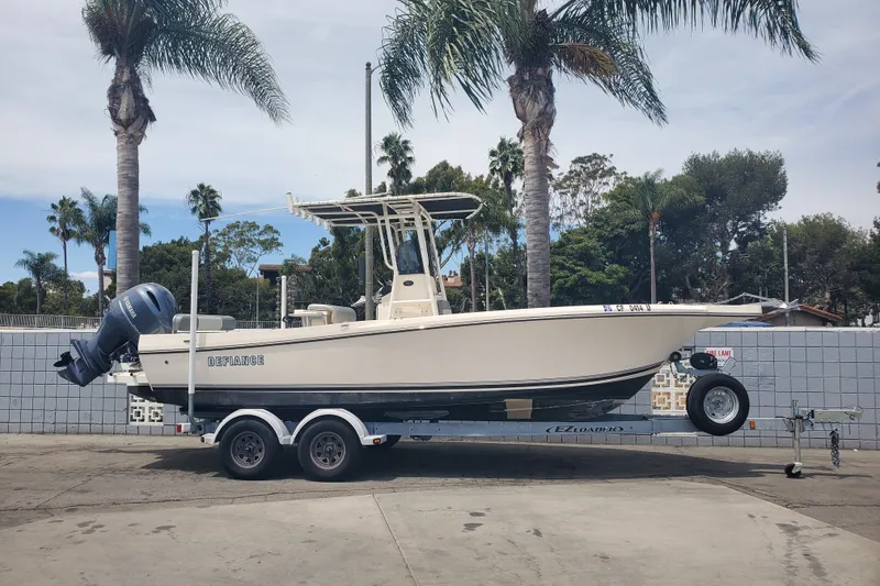 The Image of 2022 Defiance Commander 220 EX boat on trailer, parked near palm trees. - 0