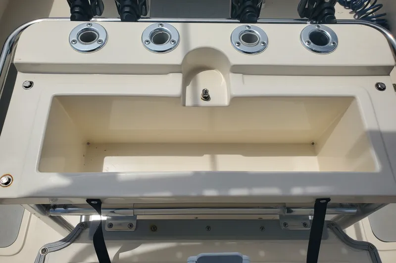 Slide: The Image of 2022 Defiance Commander 220 EX boat's fishing station with rod holders and storage compartment. - 13