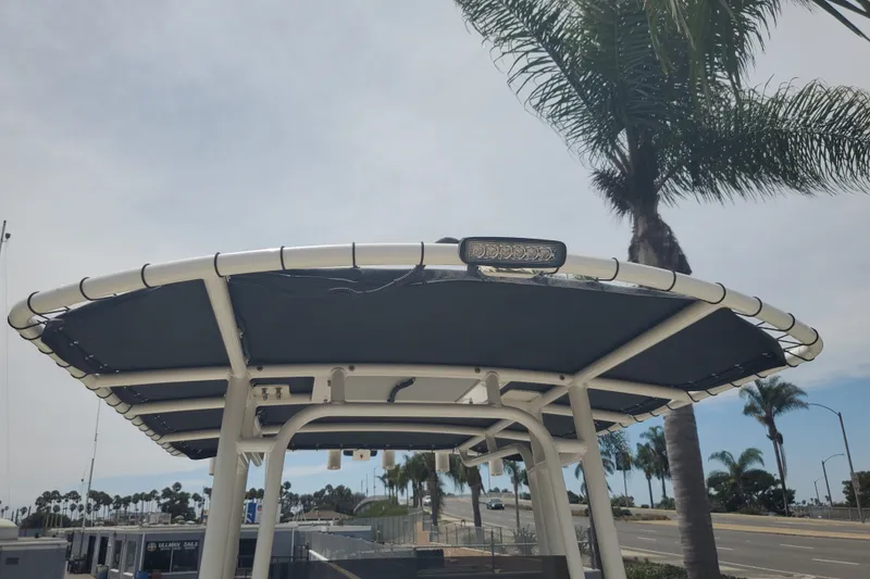 Slide: The Image of 2022 Defiance Commander 220 EX boat canopy with light, palm trees in background. - 9
