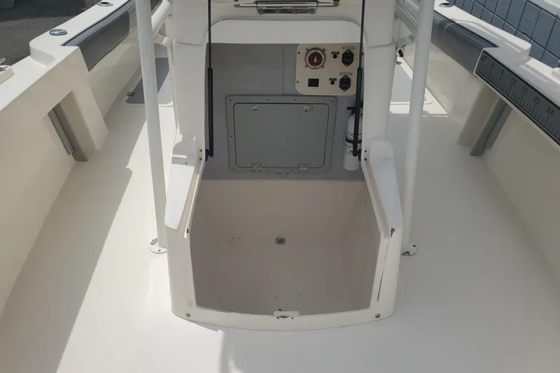 Slide: The Image of 2022 Defiance Commander 220 EX boat interior with open storage compartment and control panel. - 7