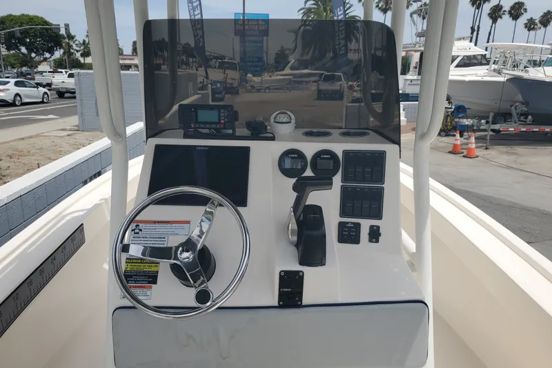 Slide: The Image of 2022 Defiance Commander 220 EX boat console with steering wheel and navigation controls. - 5
