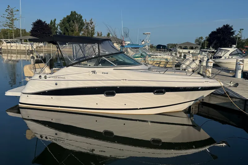 The Image of 2008 Four Winns V248 boat docked at marina, reflecting on calm water. - 0