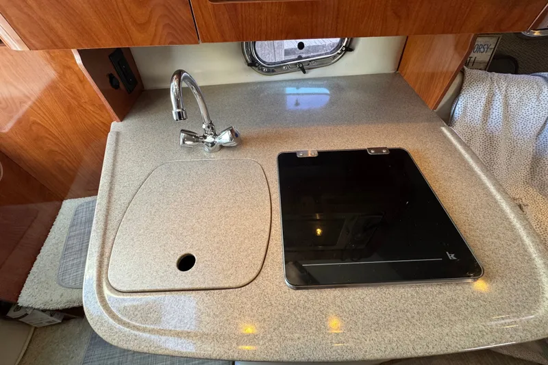 Slide: The Image of 2008 Four Winns V248 boat interior kitchen with sink and stove. - 18