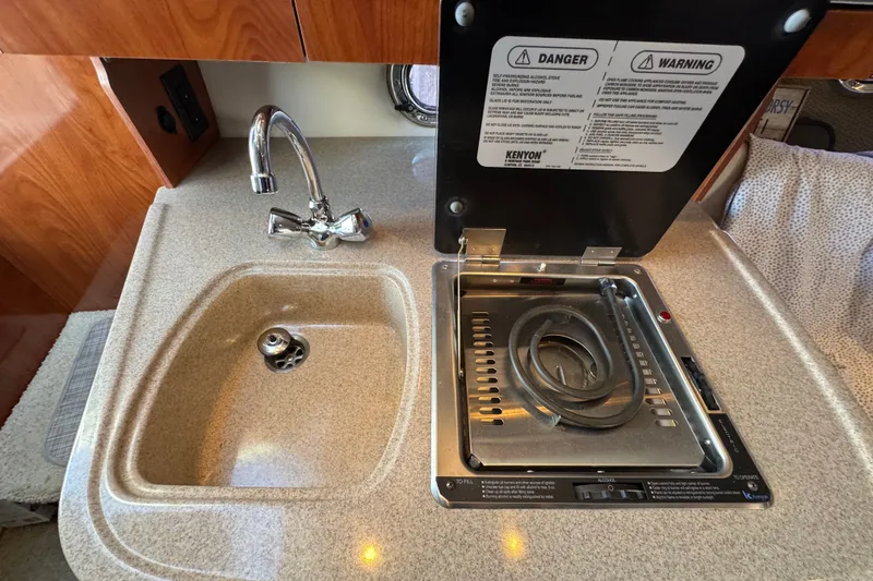 Slide: The Image of 2008 Four Winns V248 boat kitchenette with sink and stove. - 17