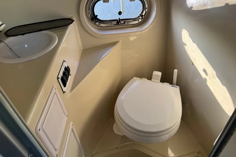 Slide: The Image of 2008 Four Winns V248 boat bathroom with toilet, sink, and porthole window. - 19