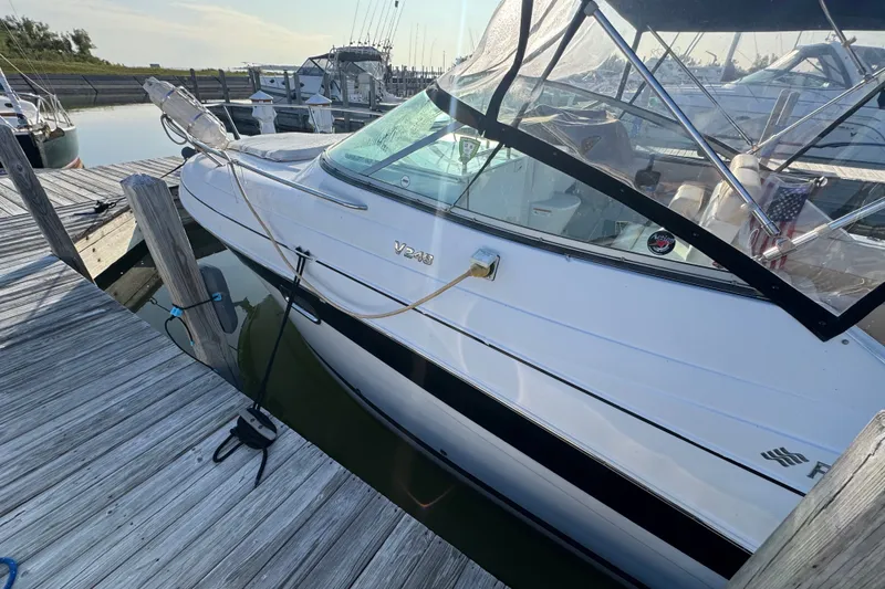 Slide: The Image of 2008 Four Winns V248 boat docked at marina with clear canopy and American flag. - 21