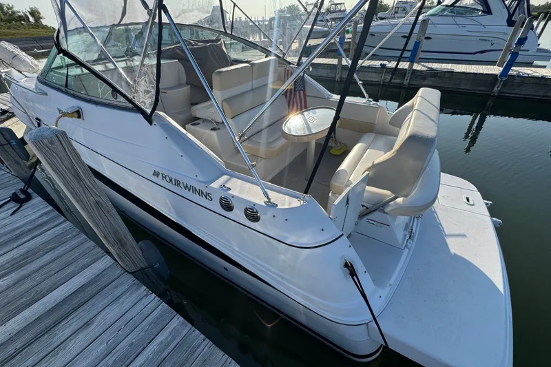 Slide: The Image of 2008 Four Winns V248 boat docked, featuring spacious seating and canopy. - 20