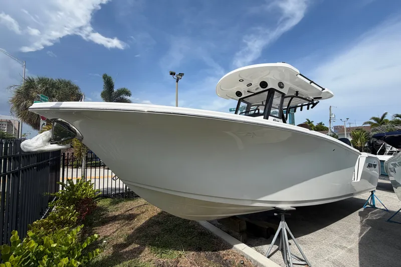 The Image of 2027 Sea Pro 262 DLX boat displayed outdoors under a clear blue sky. - 1