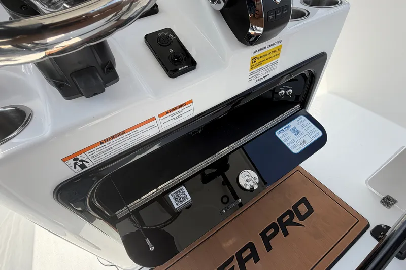Slide: The Image of 2027 Sea Pro 262 DLX boat dashboard with controls and warning labels. - 29
