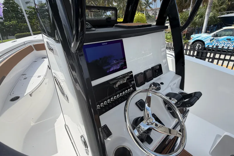 Slide: The Image of 2027 Sea Pro 262 DLX boat dashboard with steering wheel and navigation controls. - 38
